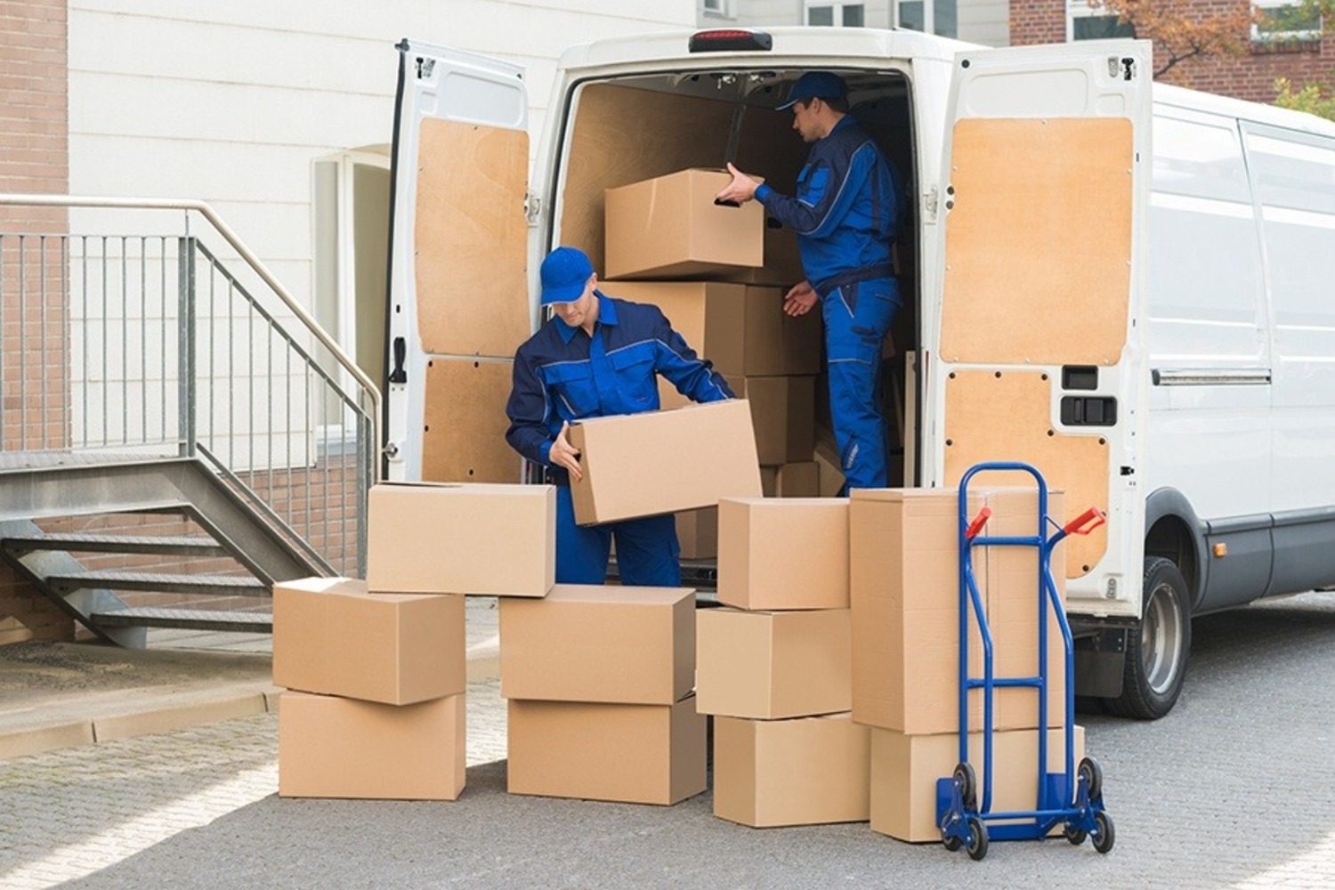 Two men loading boxes into a moving van.